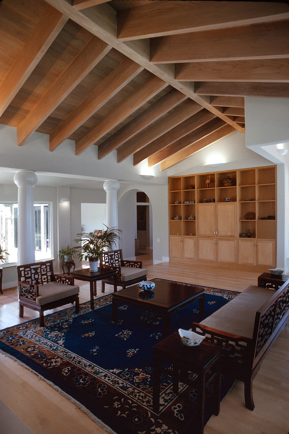 Two chairs face a coffee table and bench in a living room.