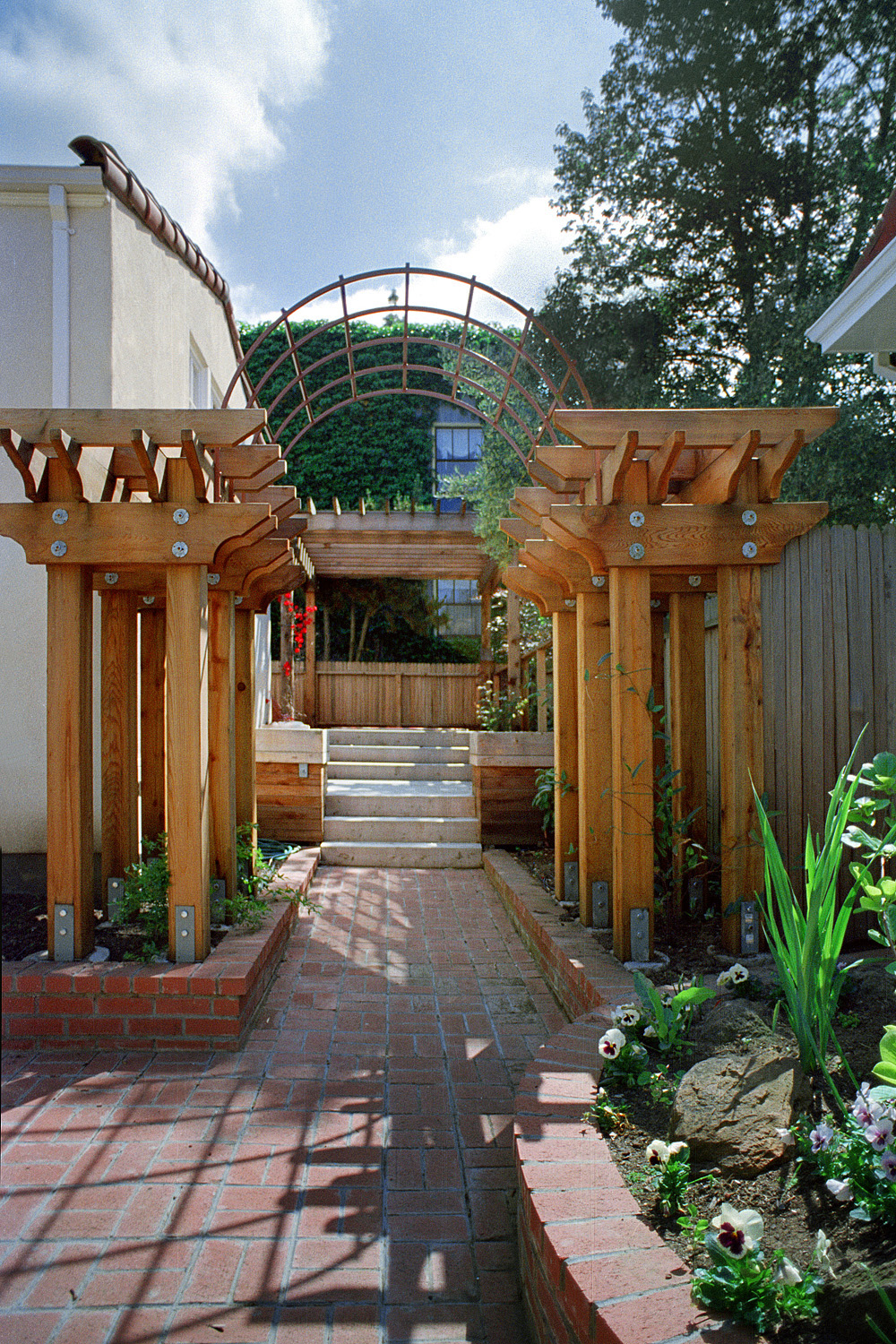 A brick pathway leads to a small wooden deck.