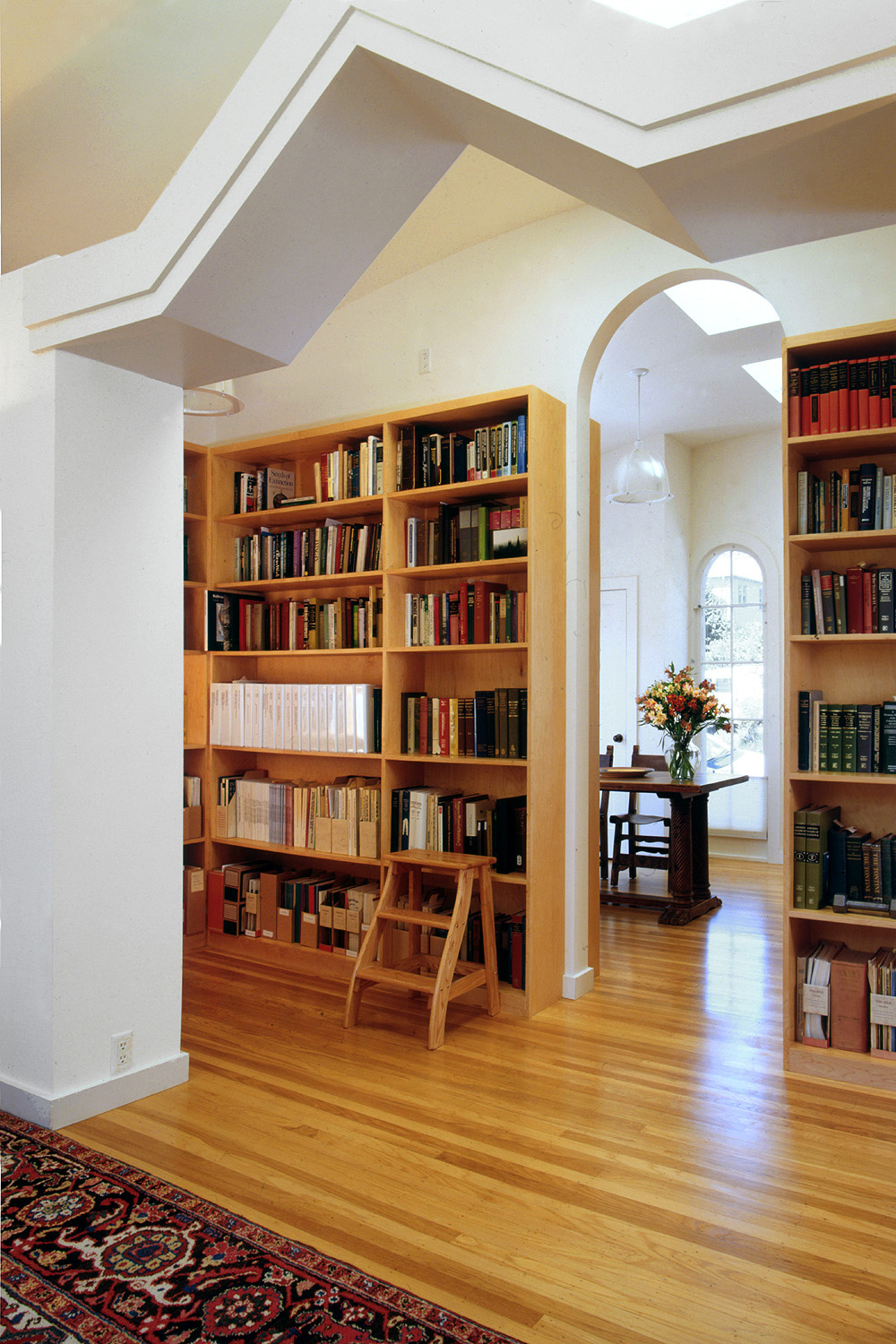 A small step stool in front of a bookshelf.