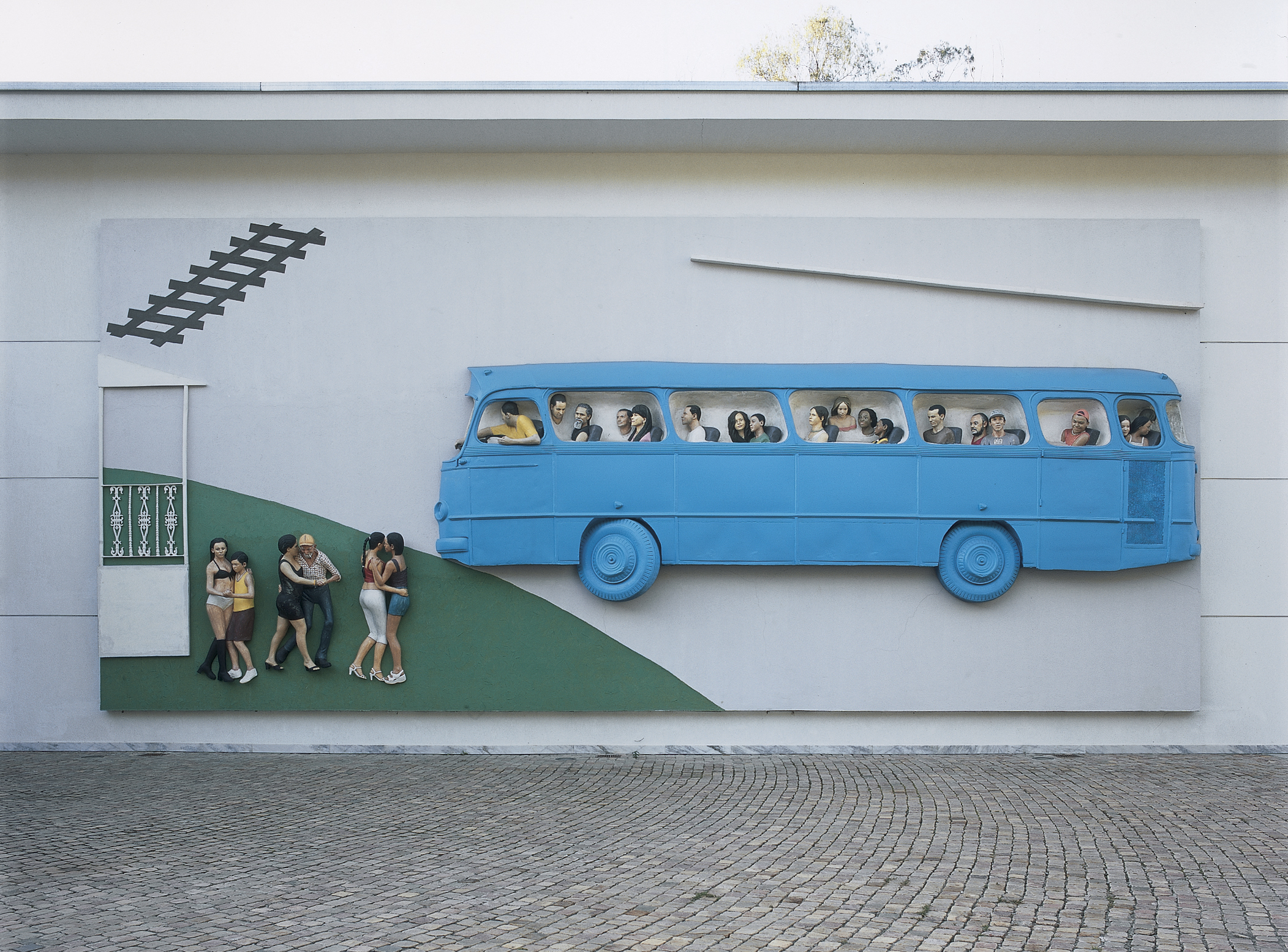 outdoor sculpture relief of a bus and people walking towards it