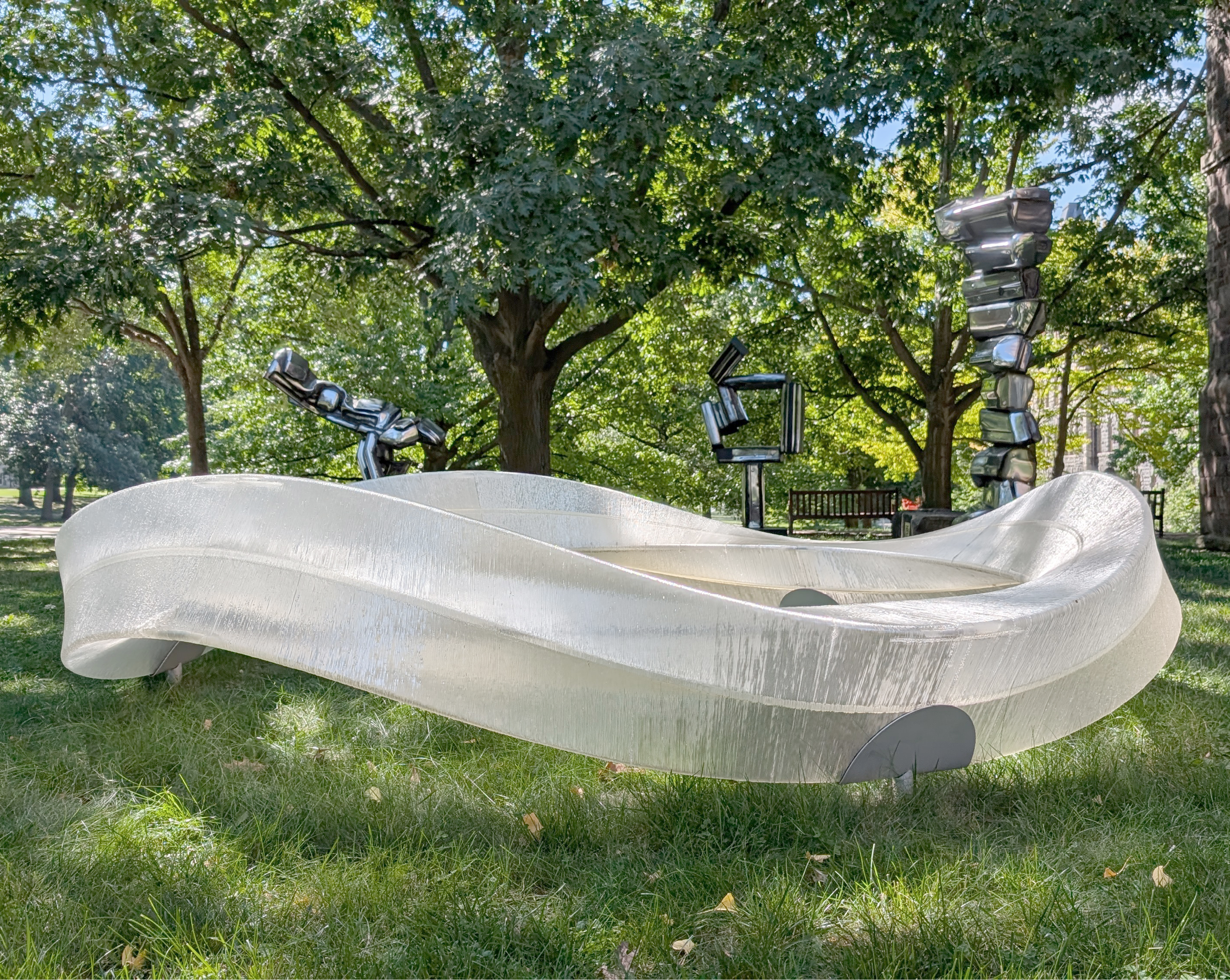 a 3d printed closed loop structure resting upon pedestals stuck in the grass