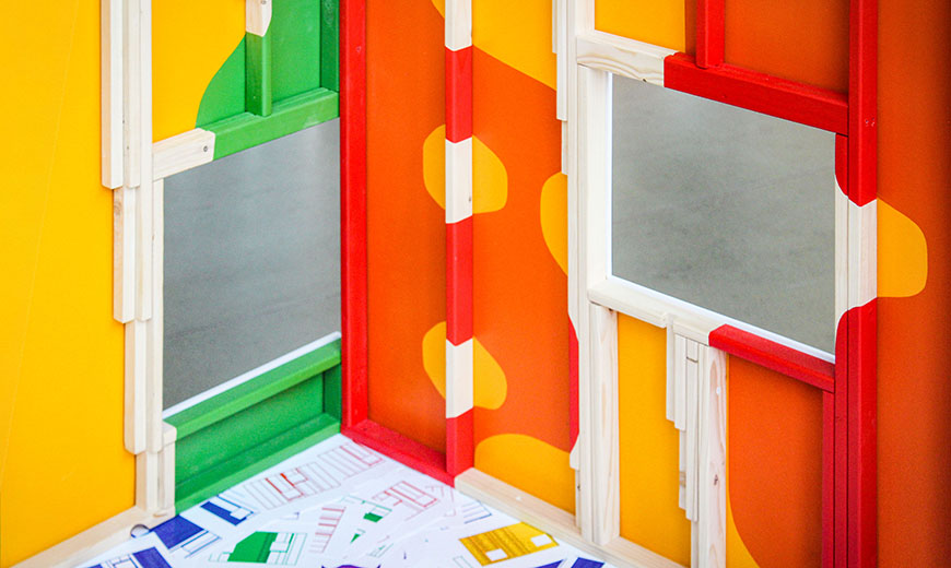 Two adjacently connected, multicolored walls. Each wall has a square window.