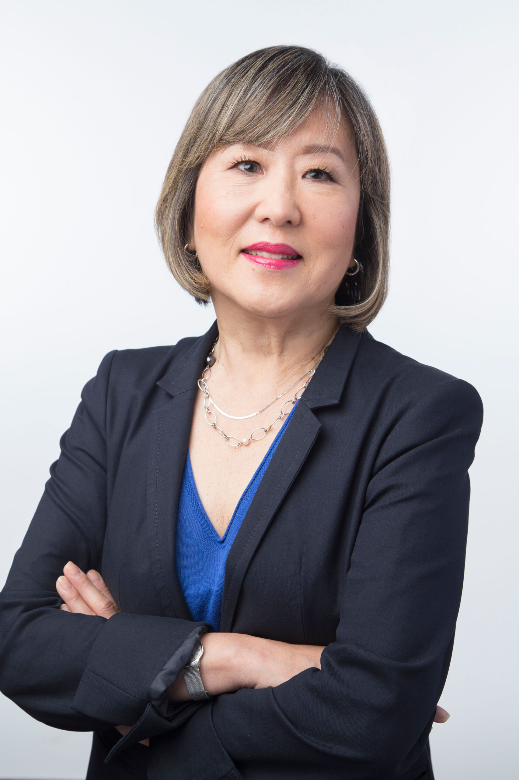 Photo of a woman dressed professionally in a black blazer over a blue blouse.
