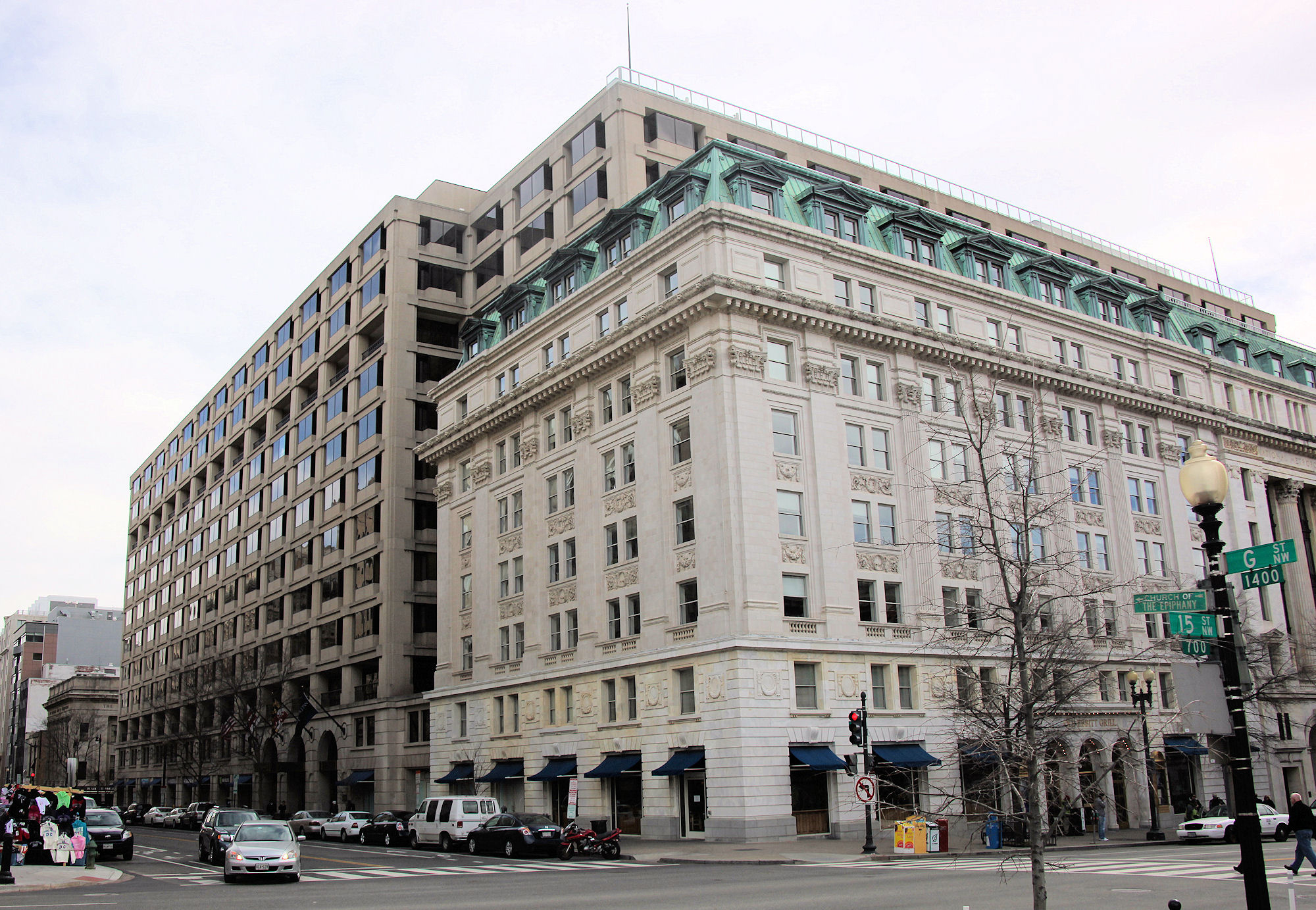 A multistory tan building with a cloudy sky in the background.