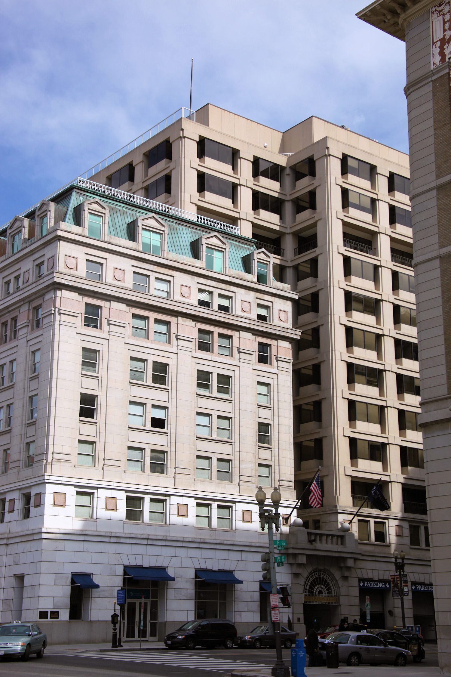 Two multistory tan buildings with a blue sky in the background.