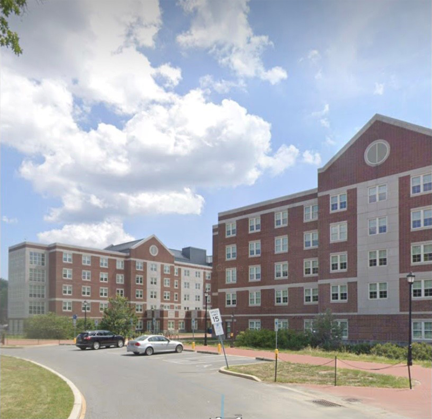 A red brick, multistory building, with rows of windows.