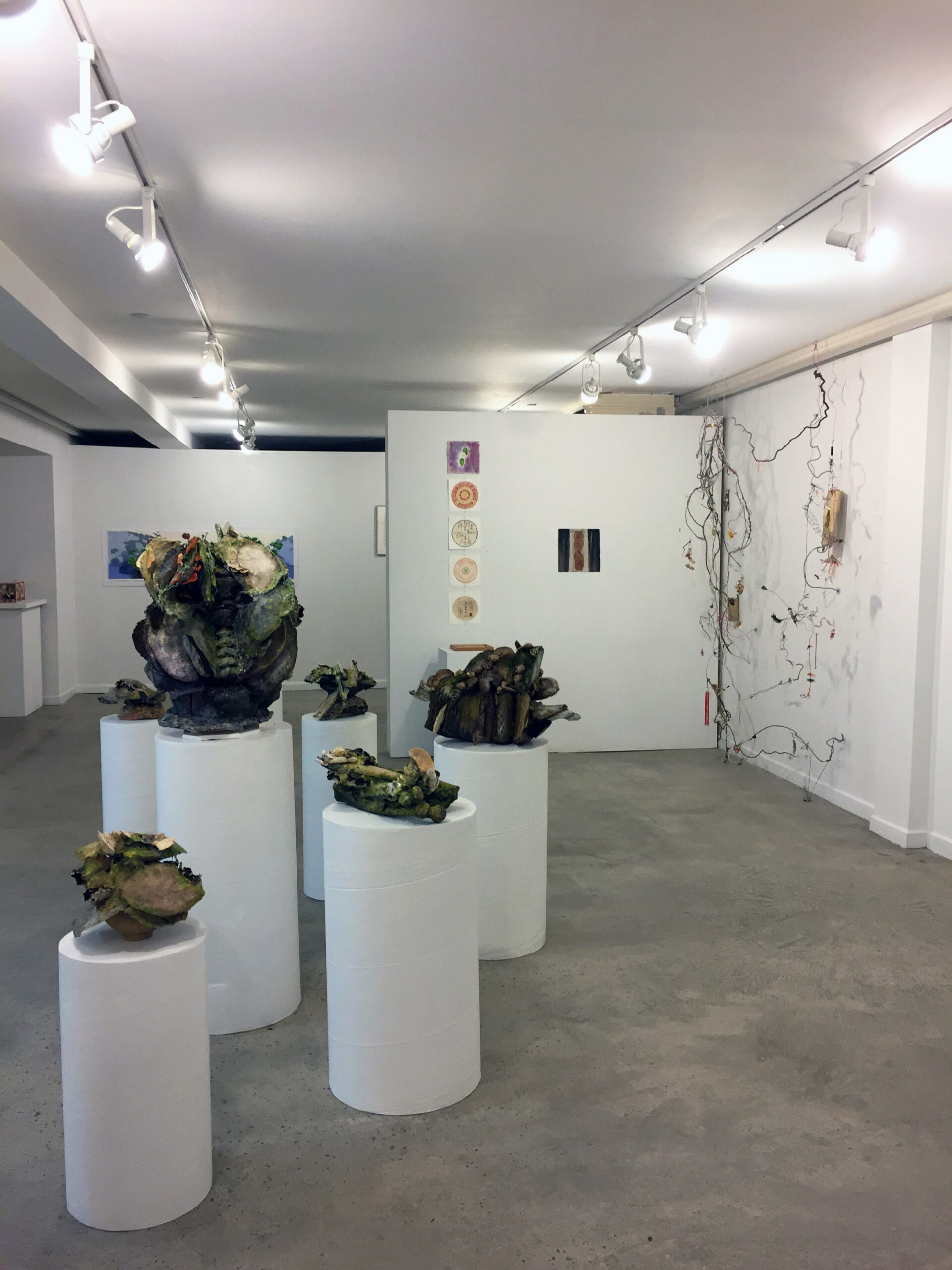 Sculptures of medicinal plants sit on round, white pillars.