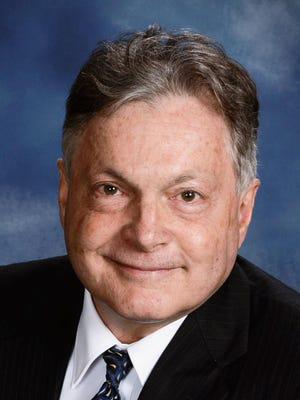 Professional headshot of a middle-aged man dressed in business attire.