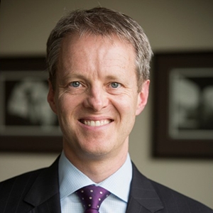 Man in a suit wearing a purple tie.