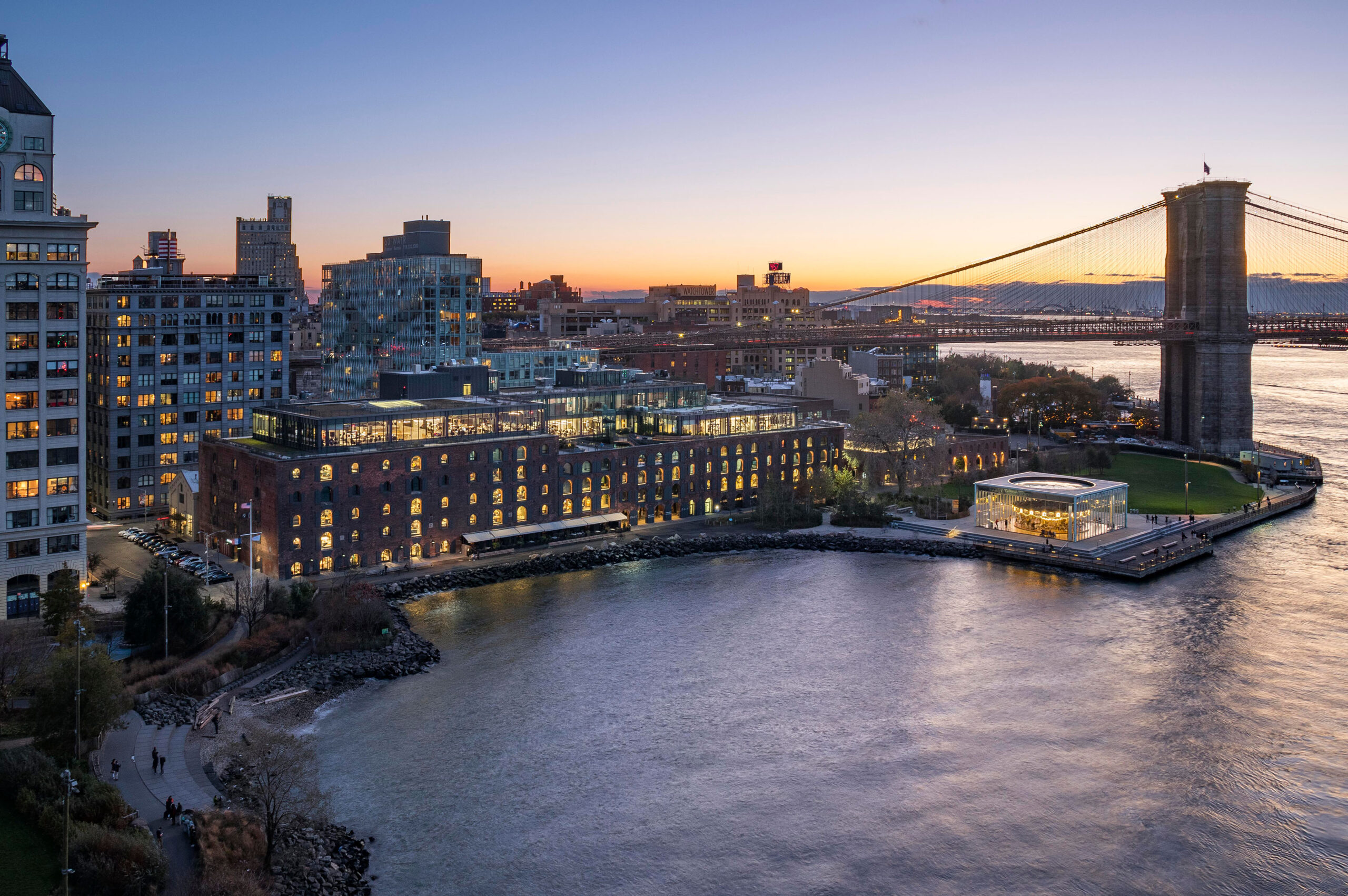 A waterfront building is lit up at dusk.