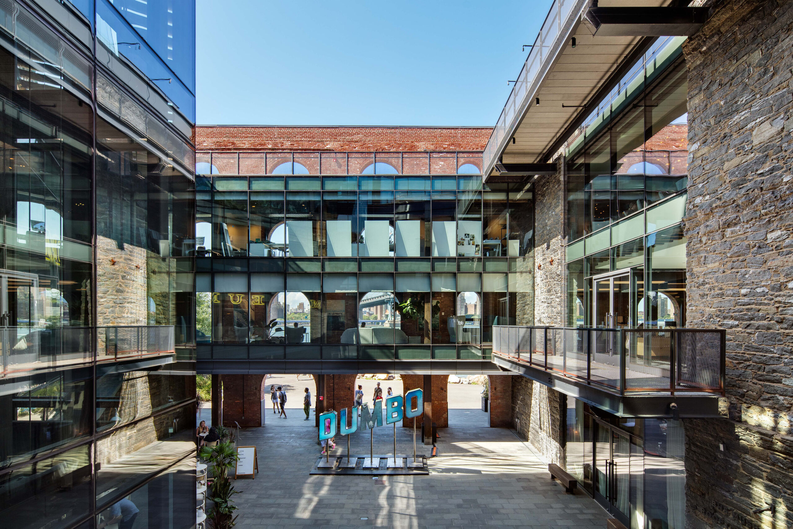 An alley between a glass building and a building with a glass and stone facade.