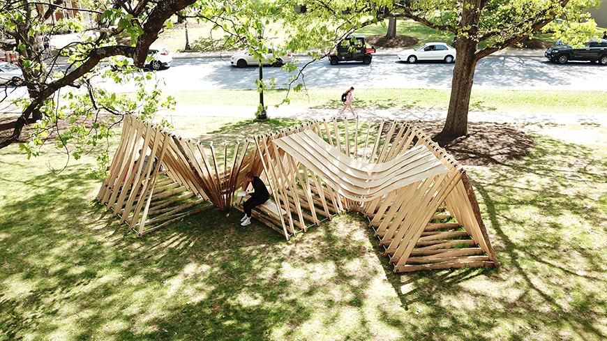 wooden sculpture on a green lawn under trees
