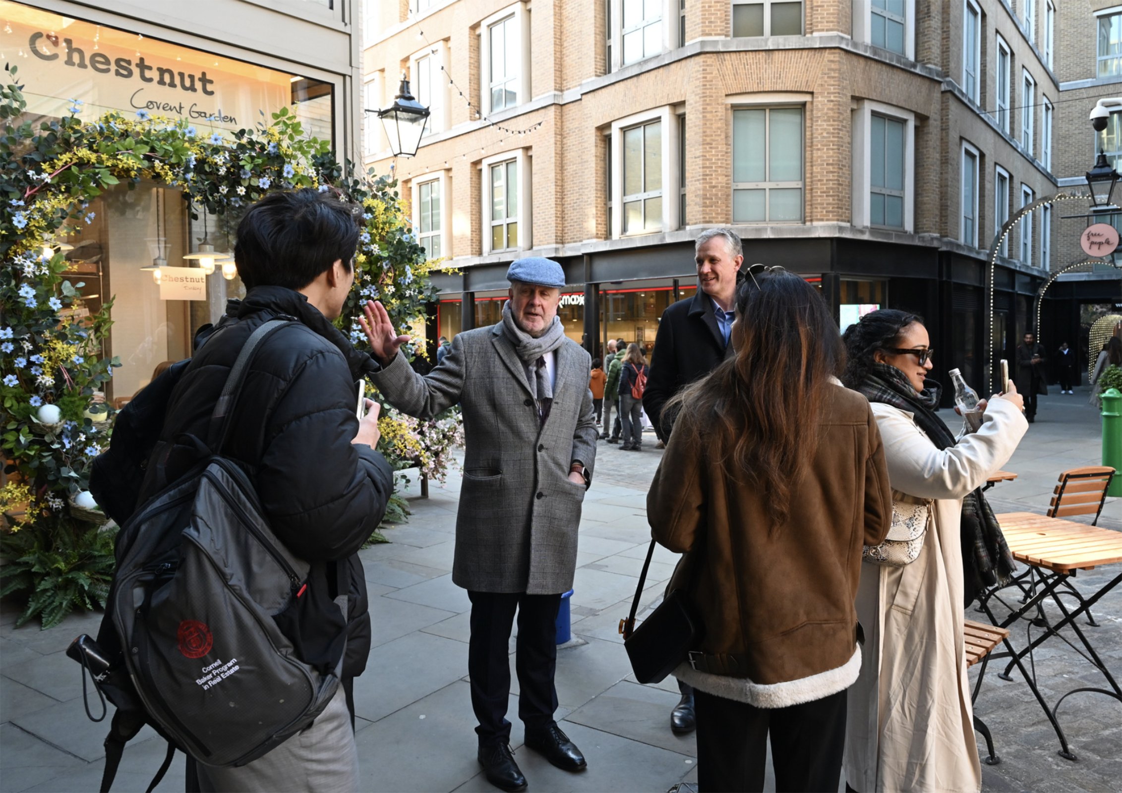 a small group of people listening to a man speak in an urban setting