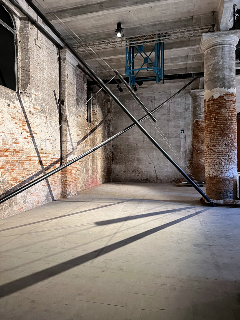 Metal poles casting shadows against a brick wall