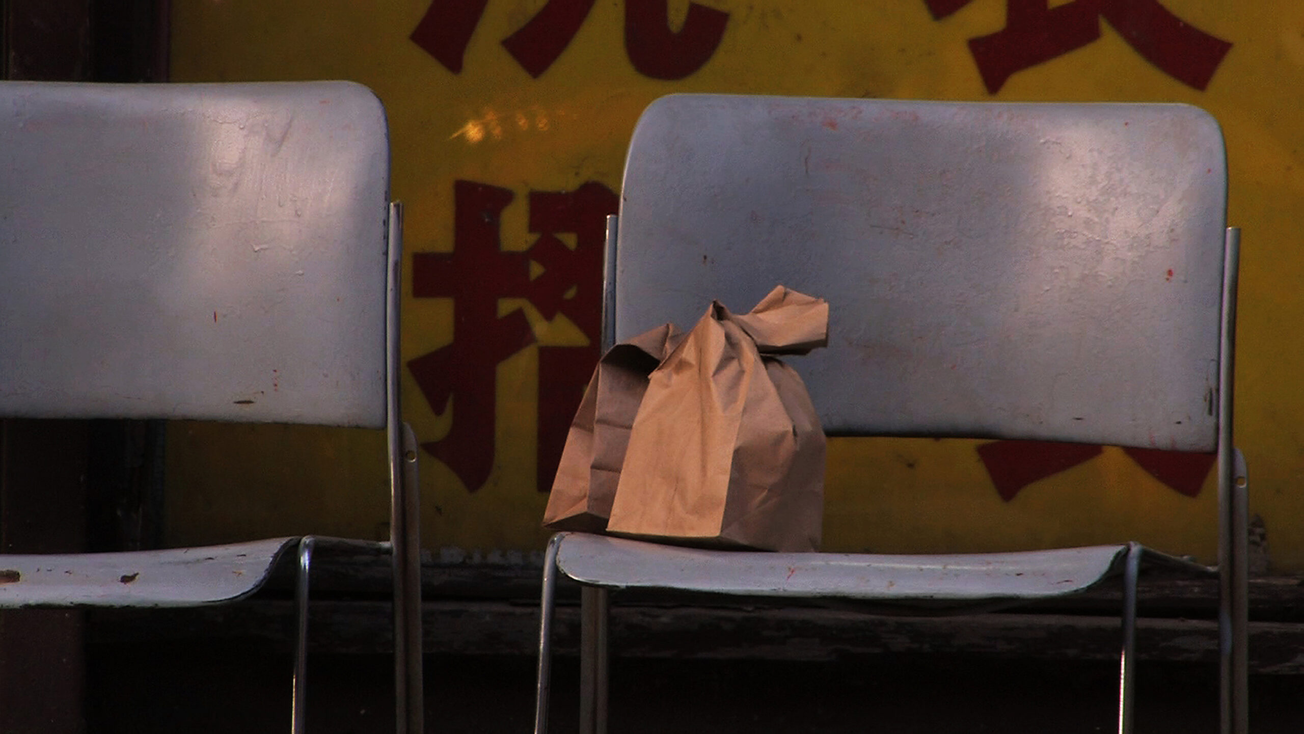 Two paper bags sit on a blue chair.