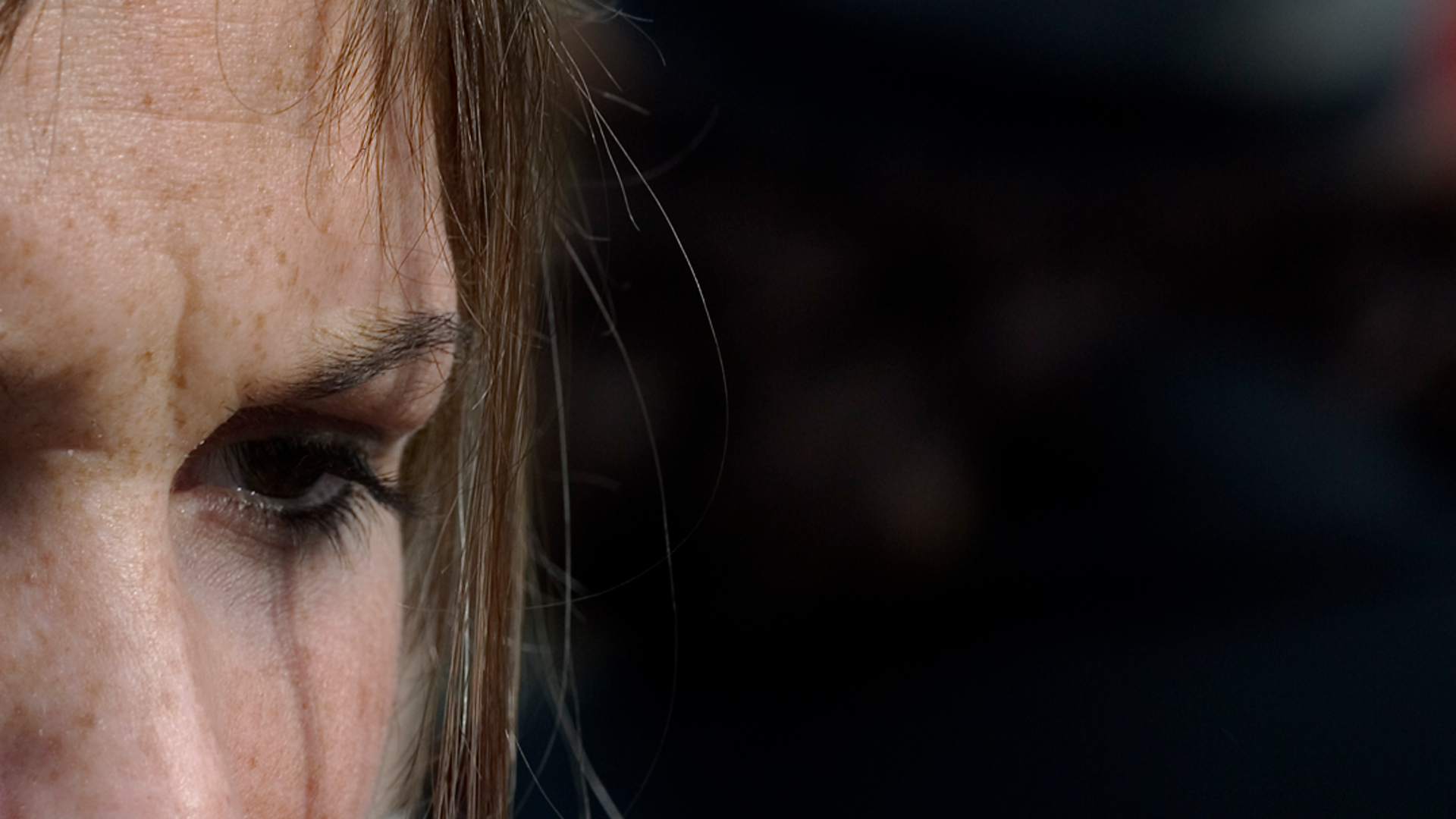 Close-up view of a woman's face—showing her forehead, left eye, and nose bridge.