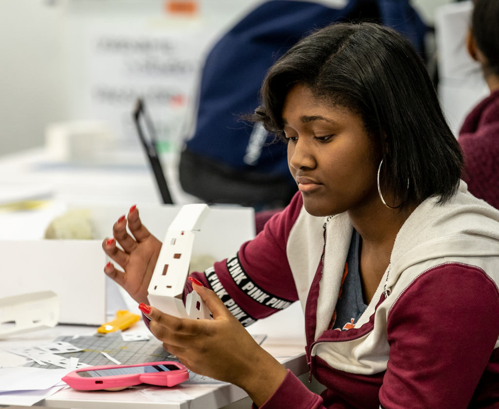Student building a model at a small white table