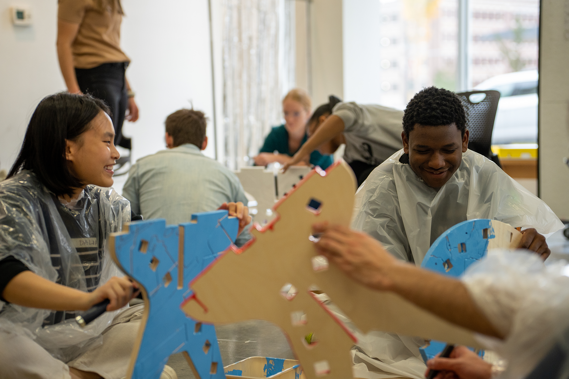 students at a table working on cardboard construction