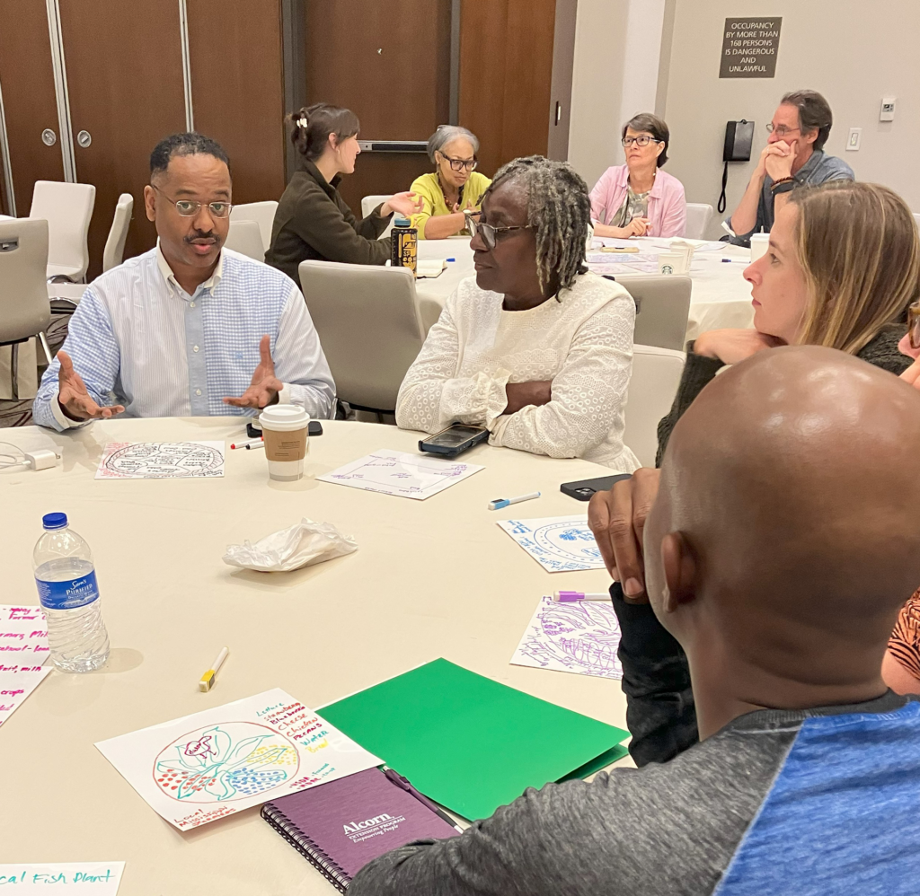 group of people gathered around a table for a meeting