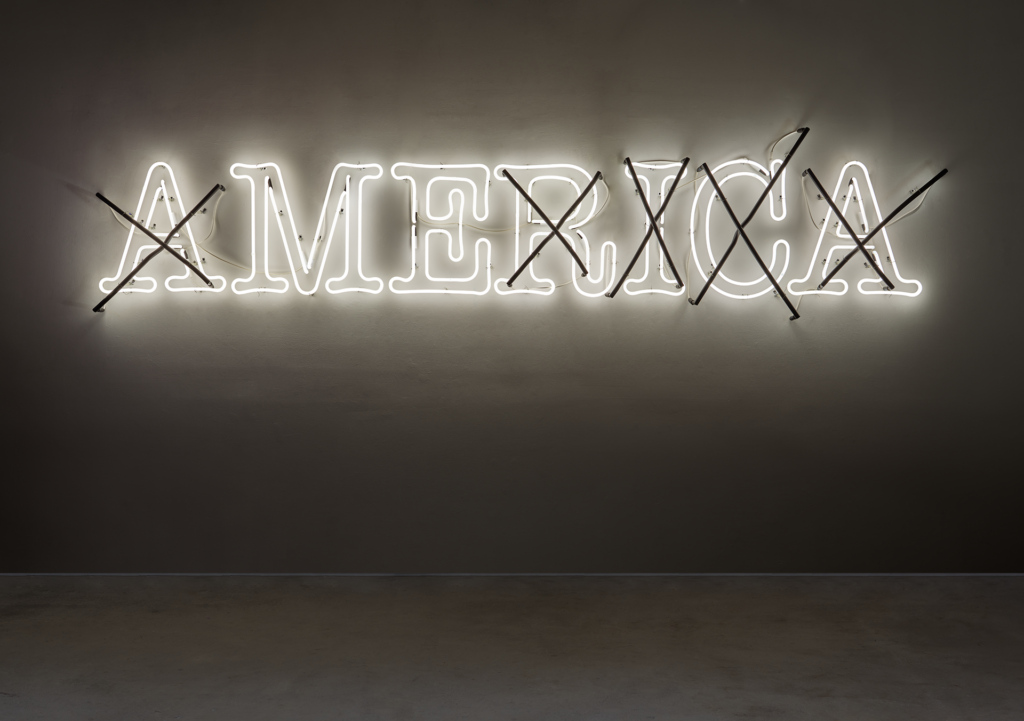 America spelled out in white neon with an X over all the letters but the the M and the E