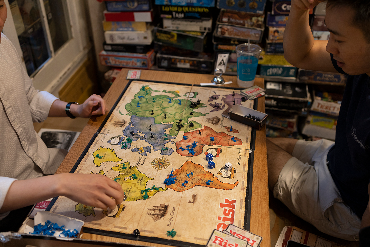 Two people sitting across from one another playing a board game.