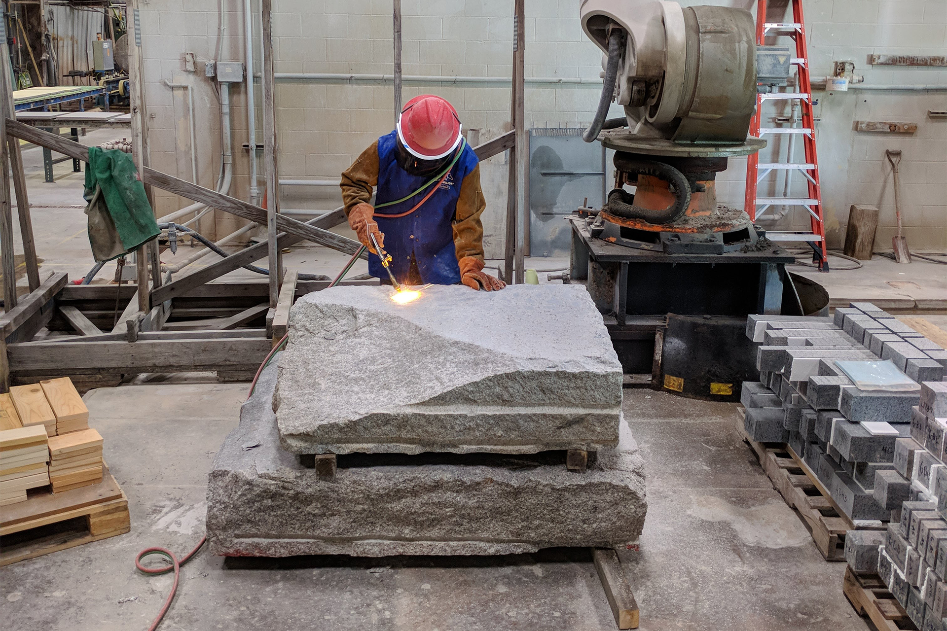 Worker cutting stone with a torch
