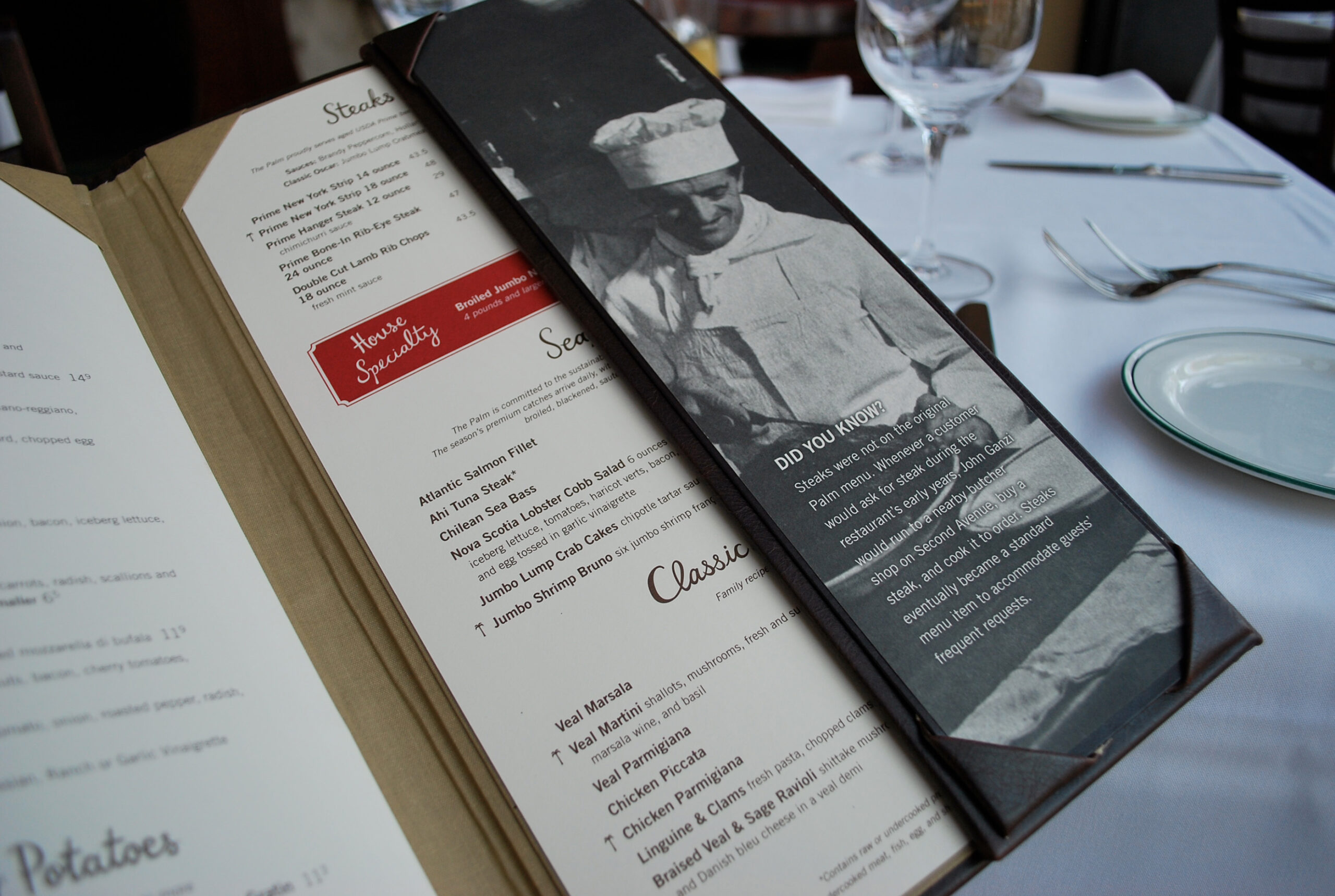 A restaurant menu lists steak, seafood, and veal dishes