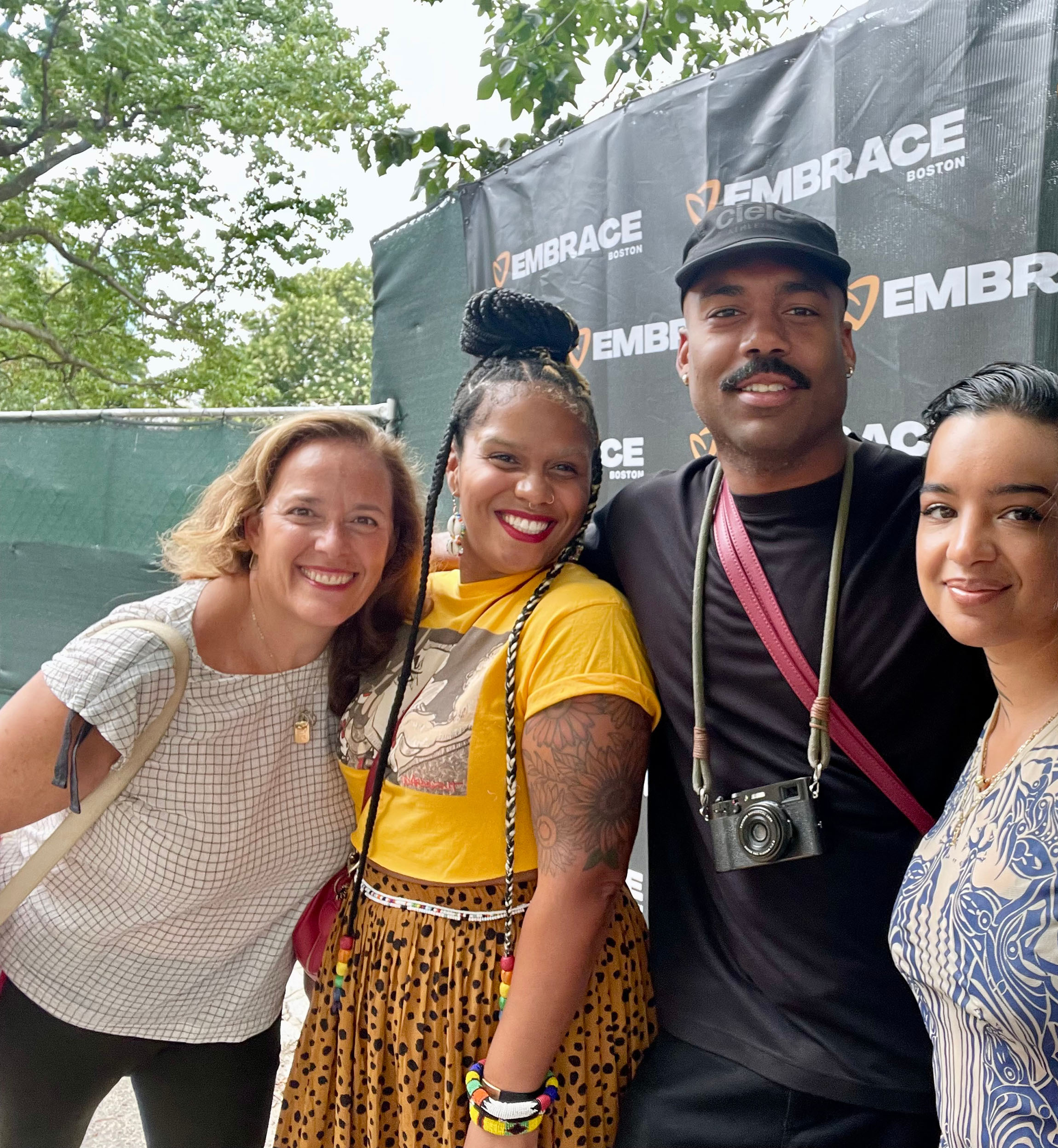 Three women and a man pose for the camera