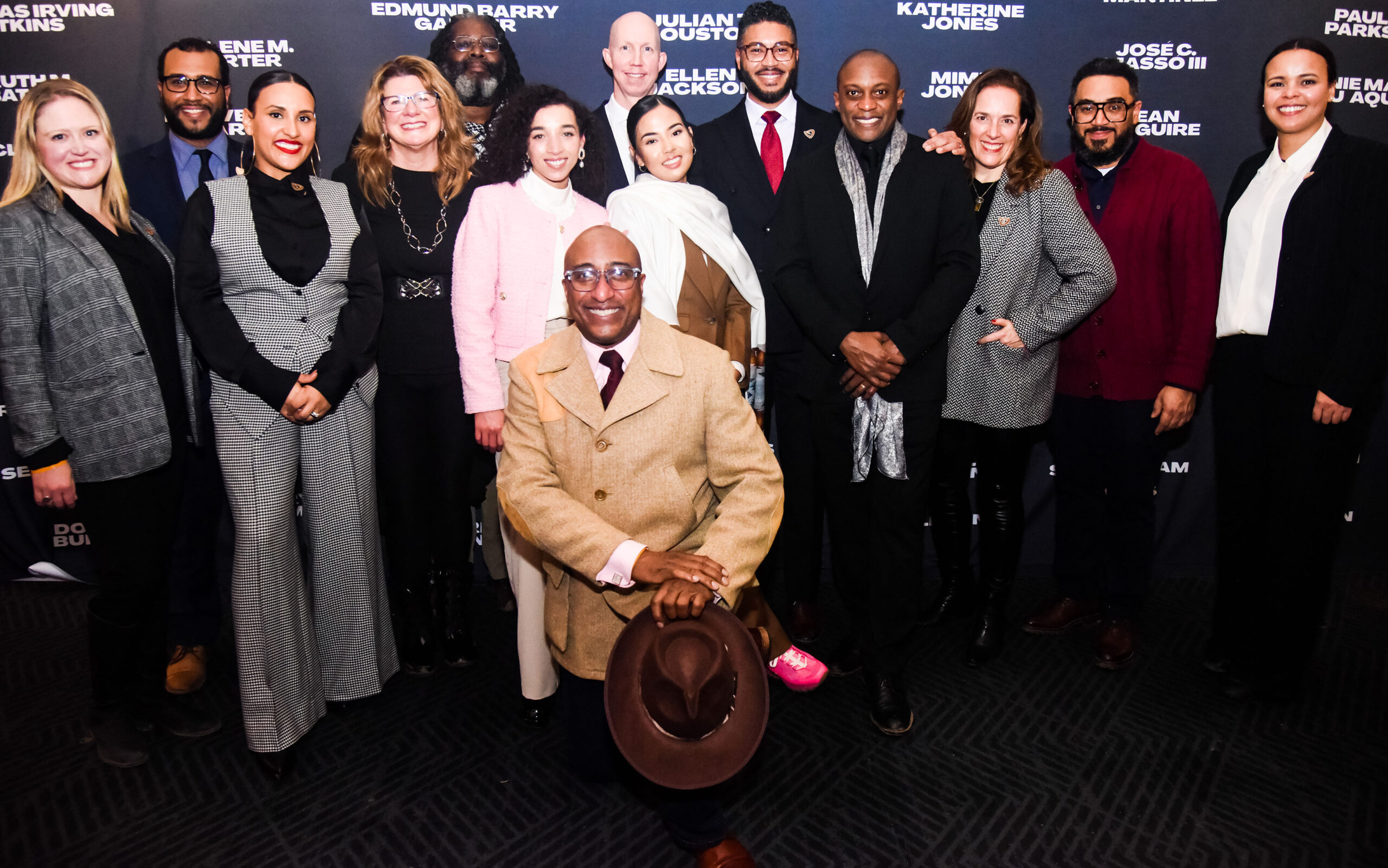 A large group of professionally dressed adults pose for a photo