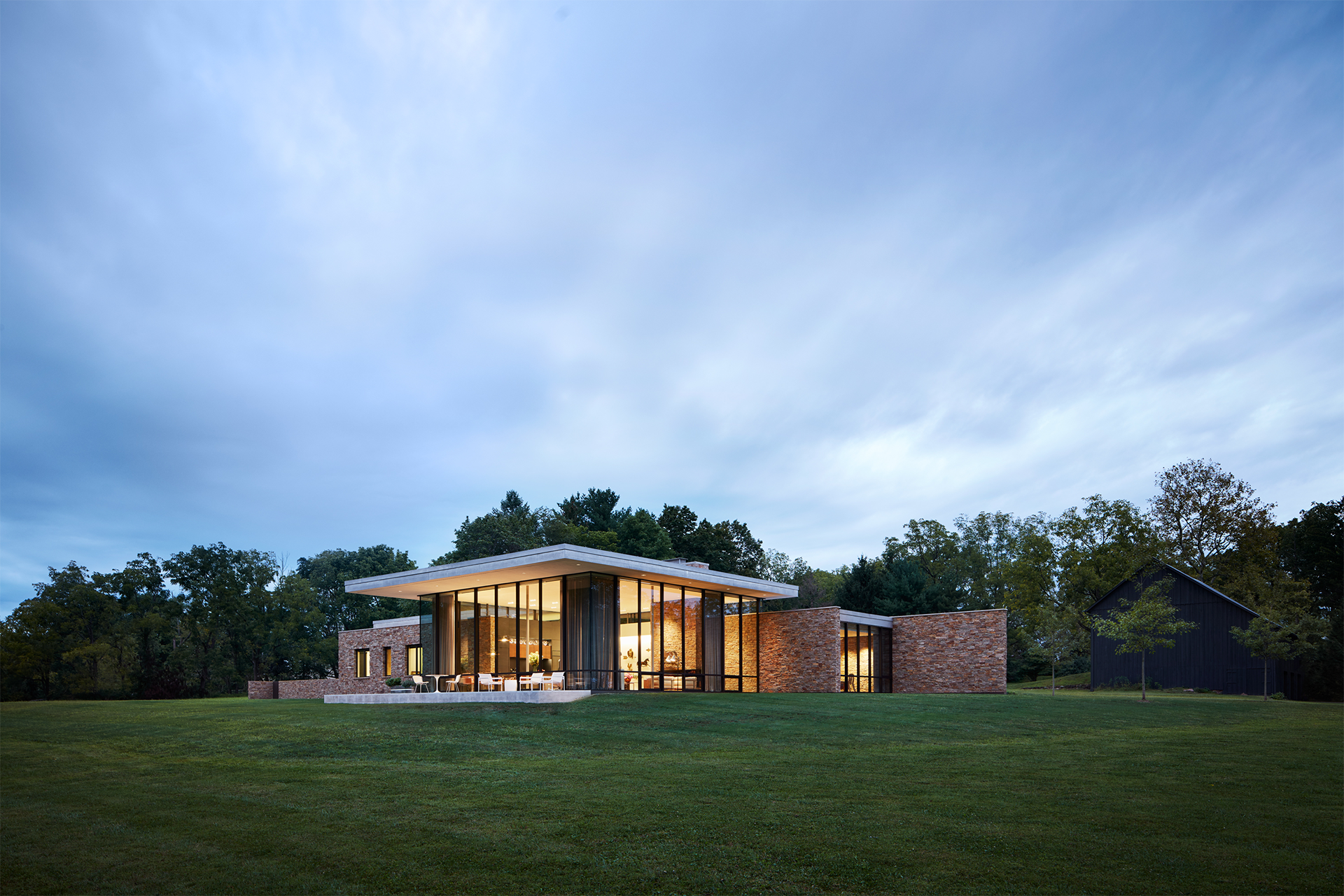 Brick house with large windows set on a large green lawn
