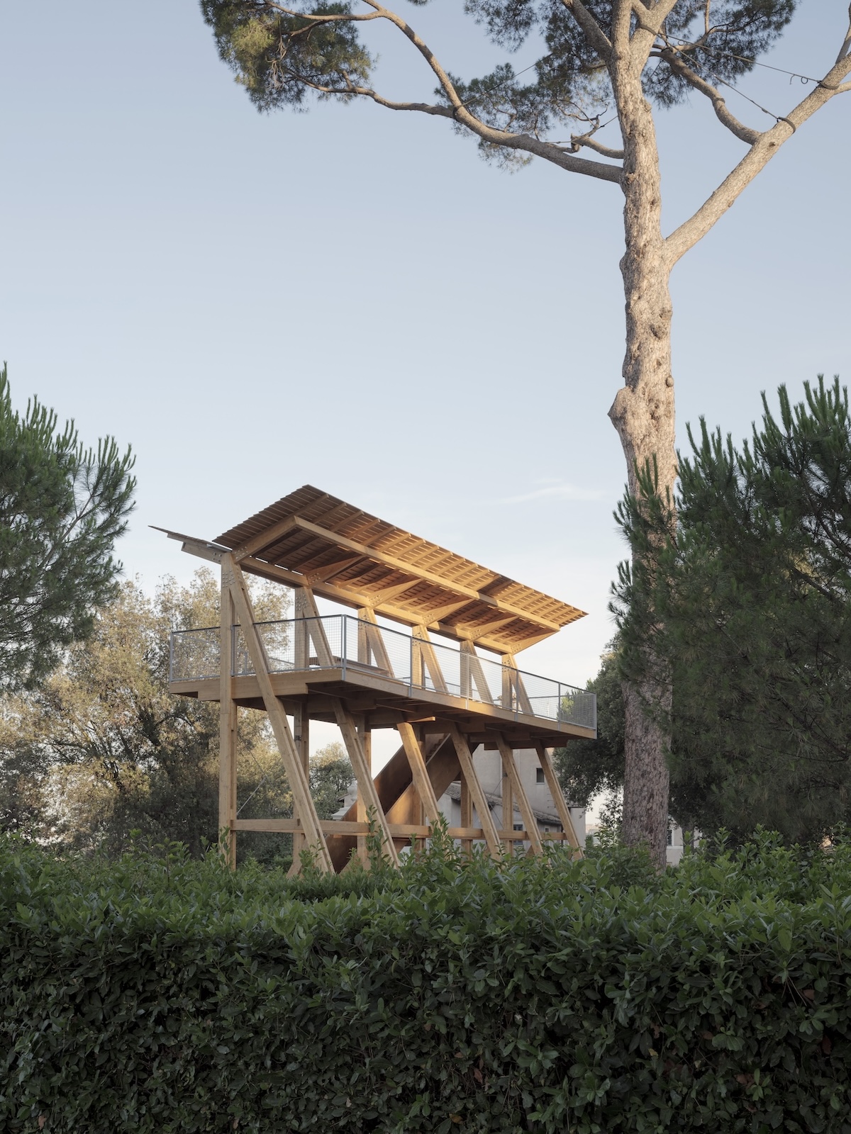 Wooden structure in the forest created with a wooden beam frame and an angled roof.