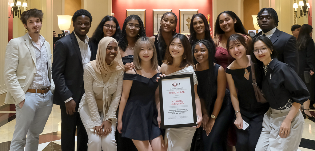 a group of people posing wearing business attire and holding a framed award