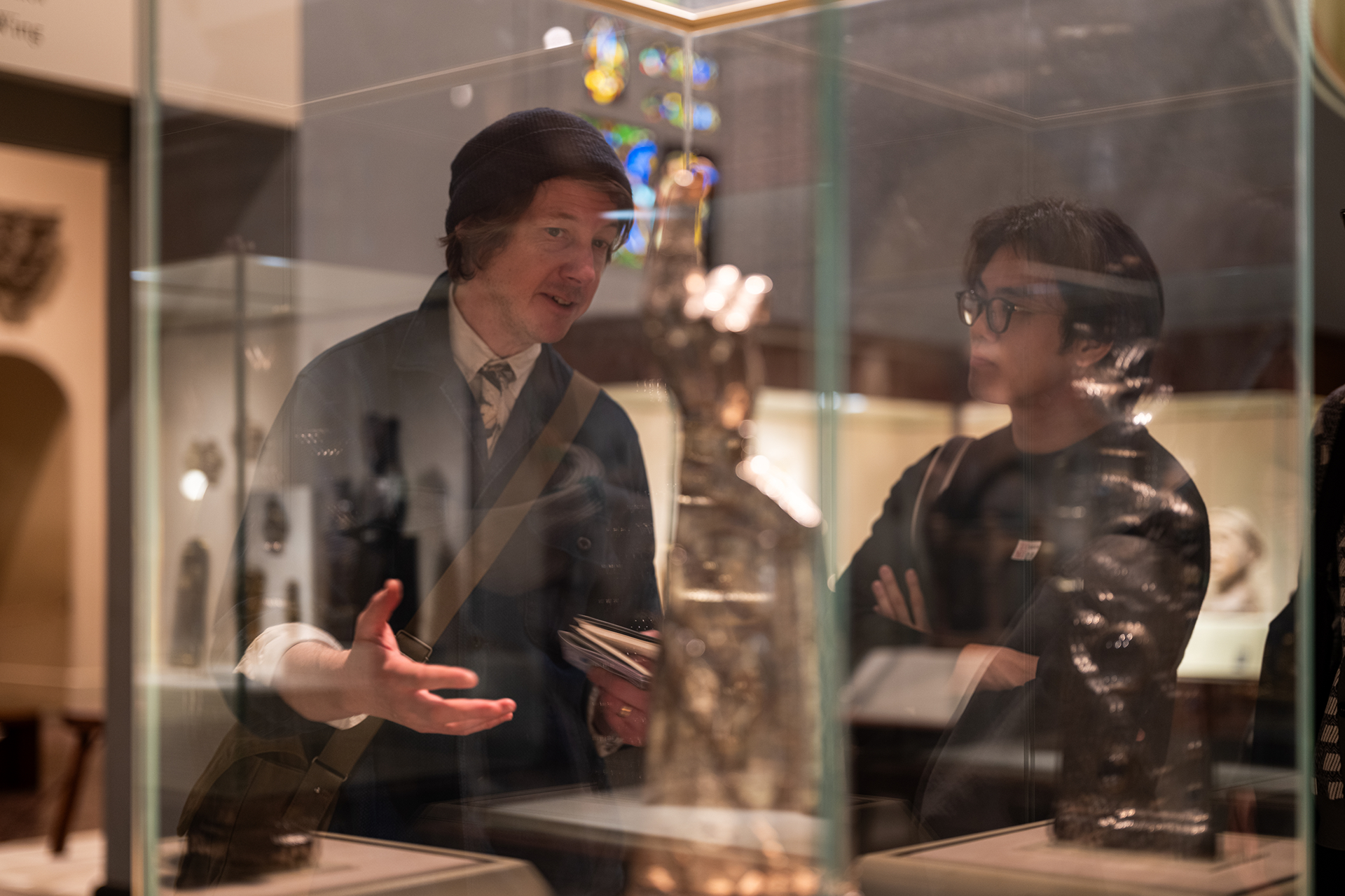 Professor and student talking near a museum disaply case