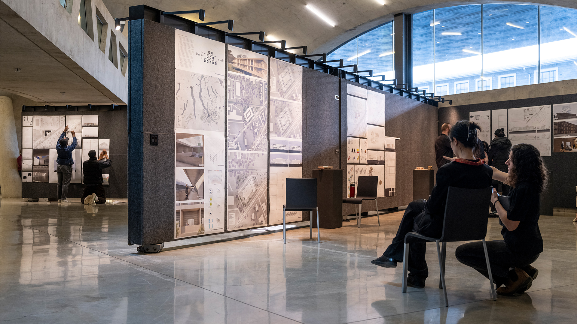 Students pinning up work for review.