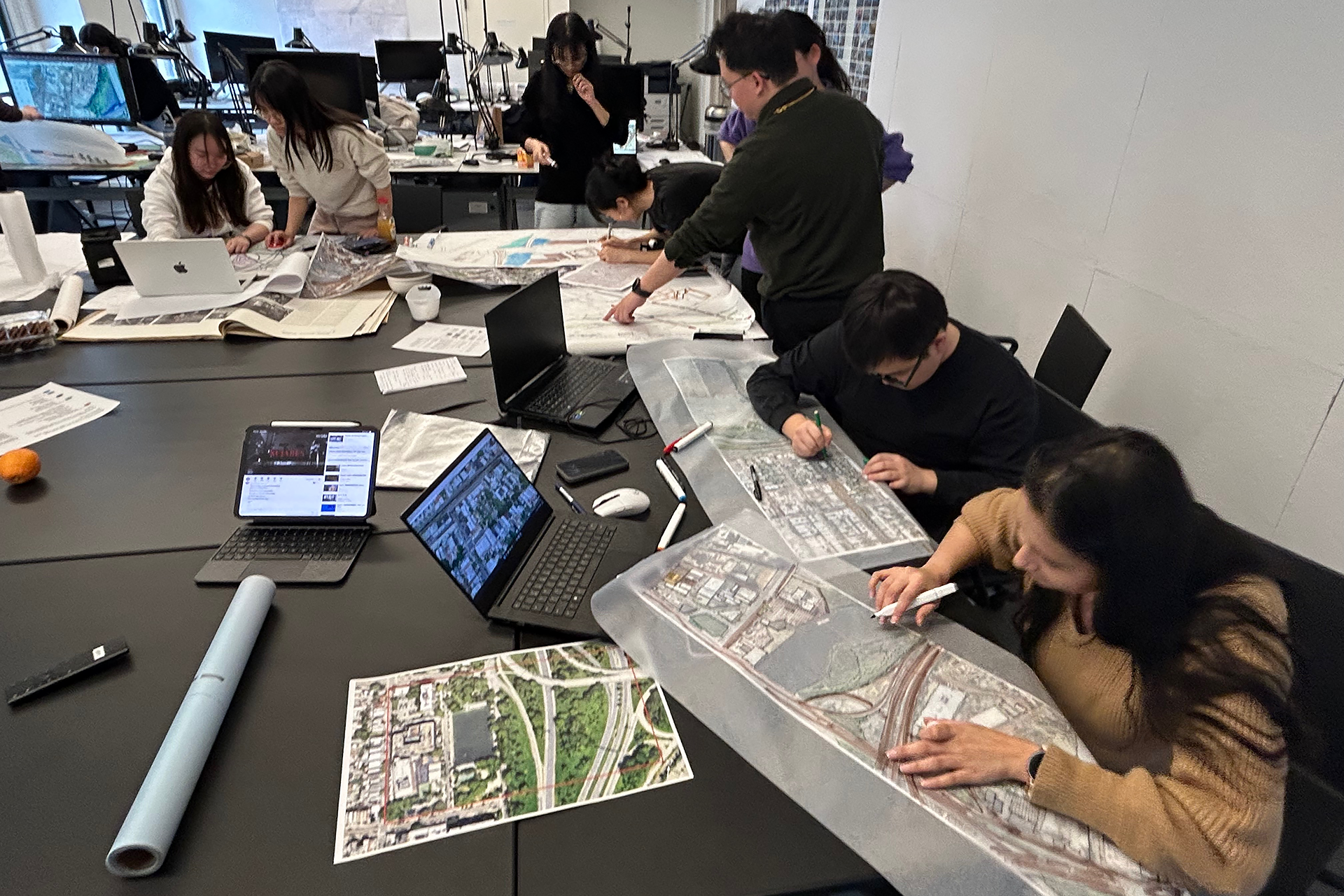Students working on models around a large table