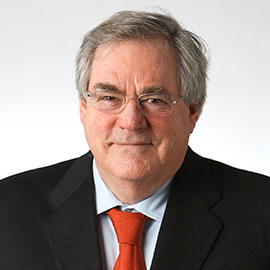 older man with thick graying hair wearing a black suit