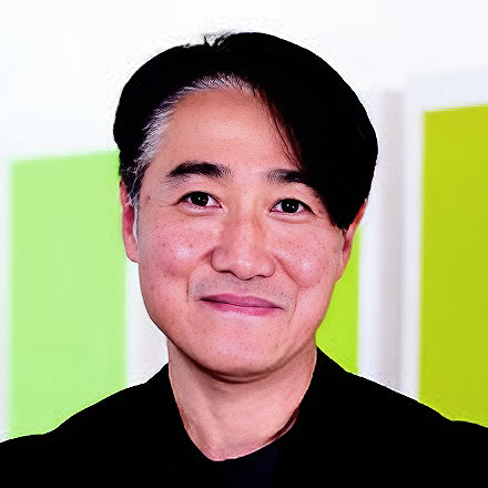 A person with short black hear smiling in front of neon green and yellow squares in the background.