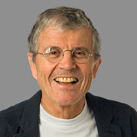 head and shoulders of a smiling man wearing glasses