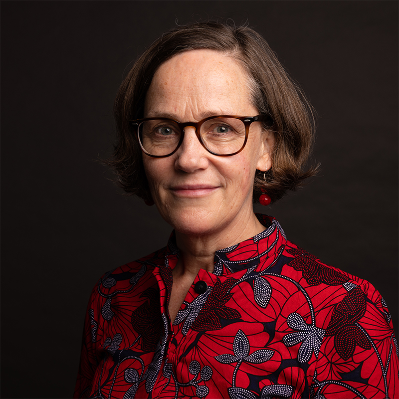 a woman with short brown hair and a black backdrop