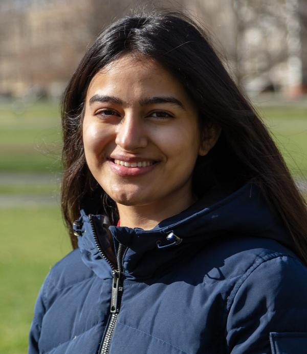 a woman with long dark hair and a puffy blue zip up jacket