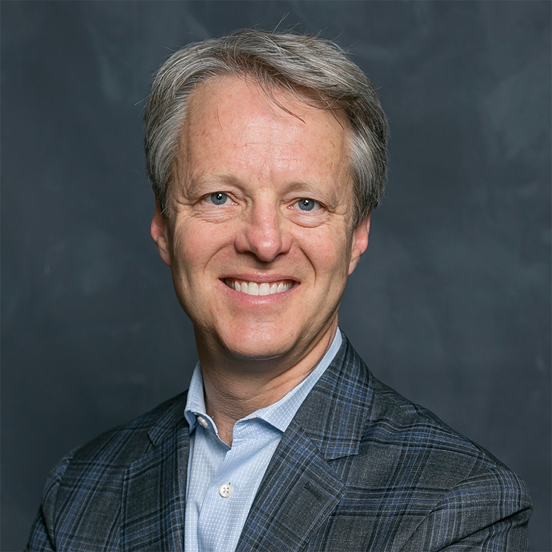 a person smiling with a blue shirt and suit jacket