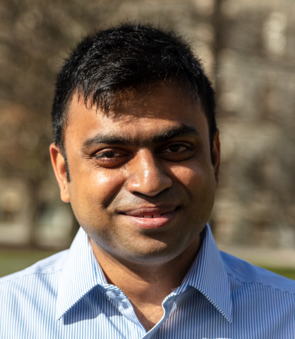 a man wearing a blue collared shirt with dark short black hair