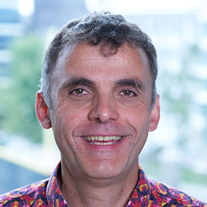 Man in brightly colored shirt smiling at the camera