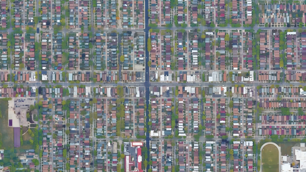 Rows of houses and buildings surrounded by streets and grass.