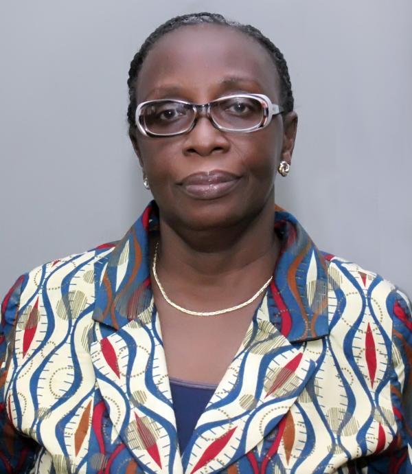 a person wearing glasses, earring, and a gold necklace with a blue, red, and cream colored shirt.