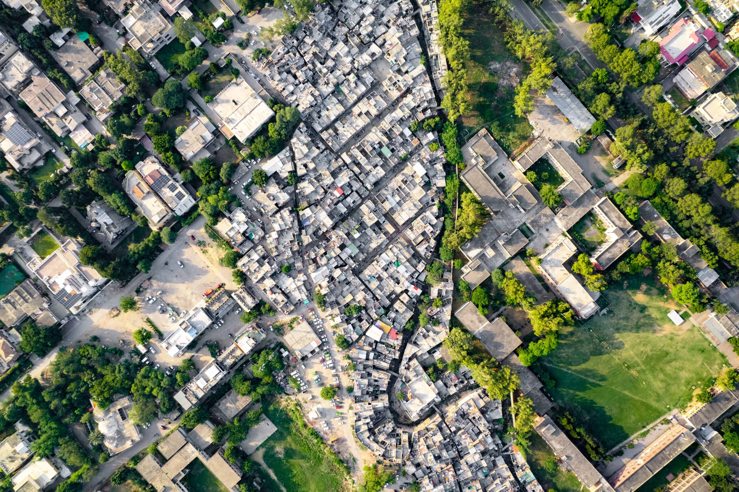 A series of large luxury spacious buildings next to smaller more dense buildings.