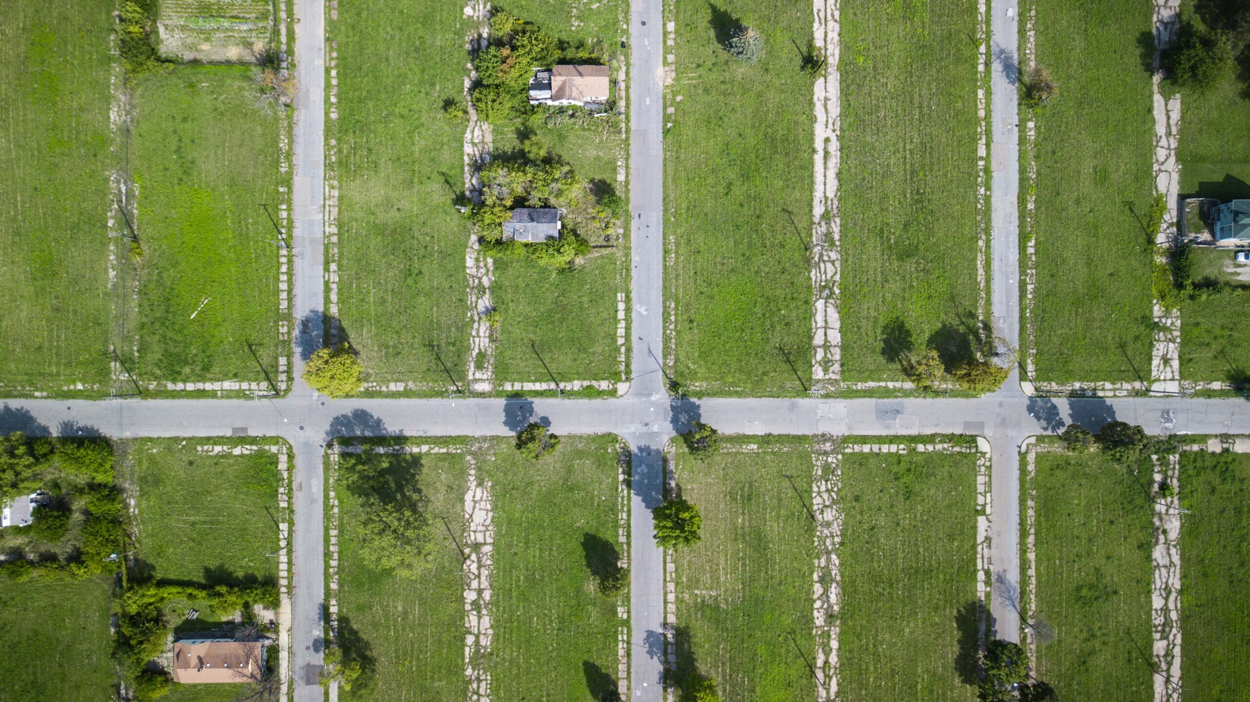 Ariel view of houses on grass with streets in between.