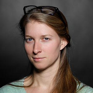 A person with long blonde hair with glasses sitting on top of her head.