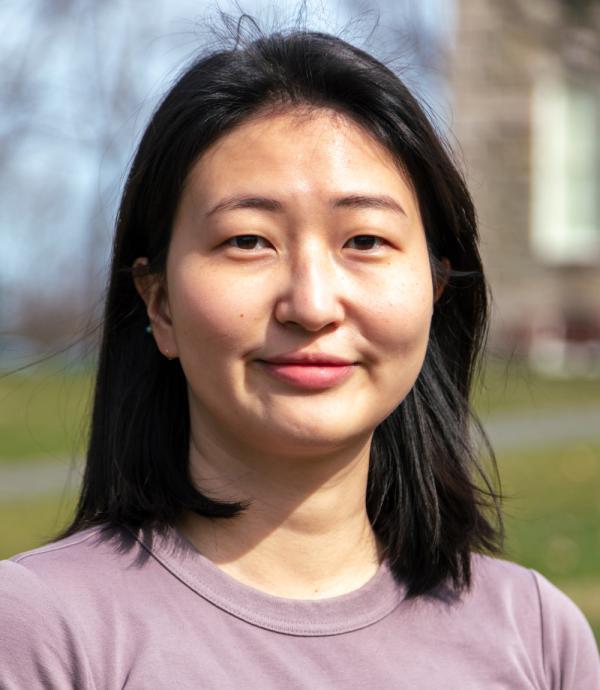 a young woman wearing a pink shirt while standing outside
