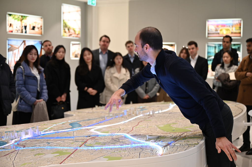 Man explains a model in front of a group of students